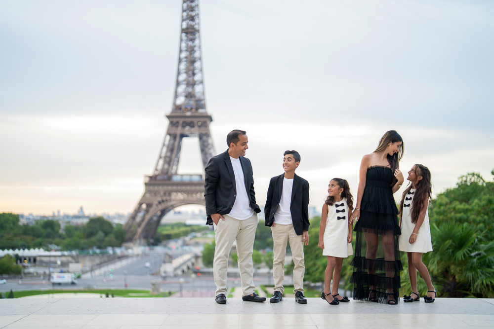 Beautifully dressed family taking professional photos at the Eiffel Tower