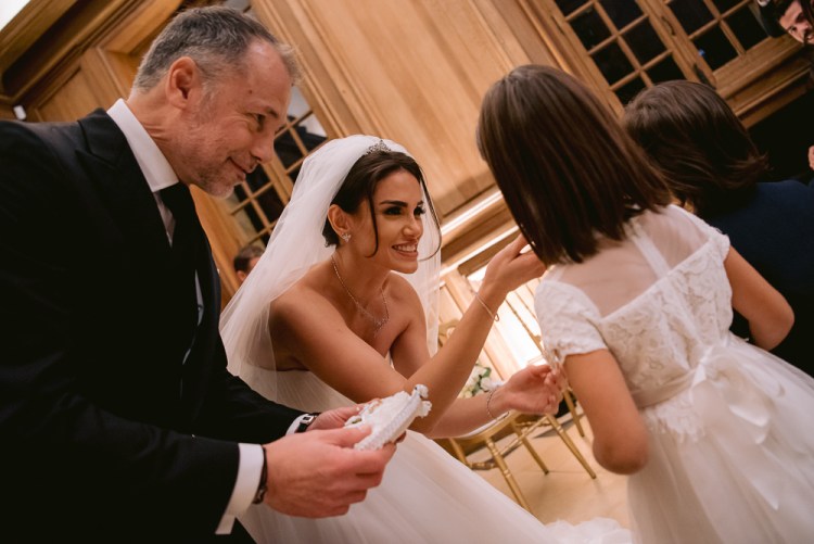 Bride talking to flower girls during destination wedding in France