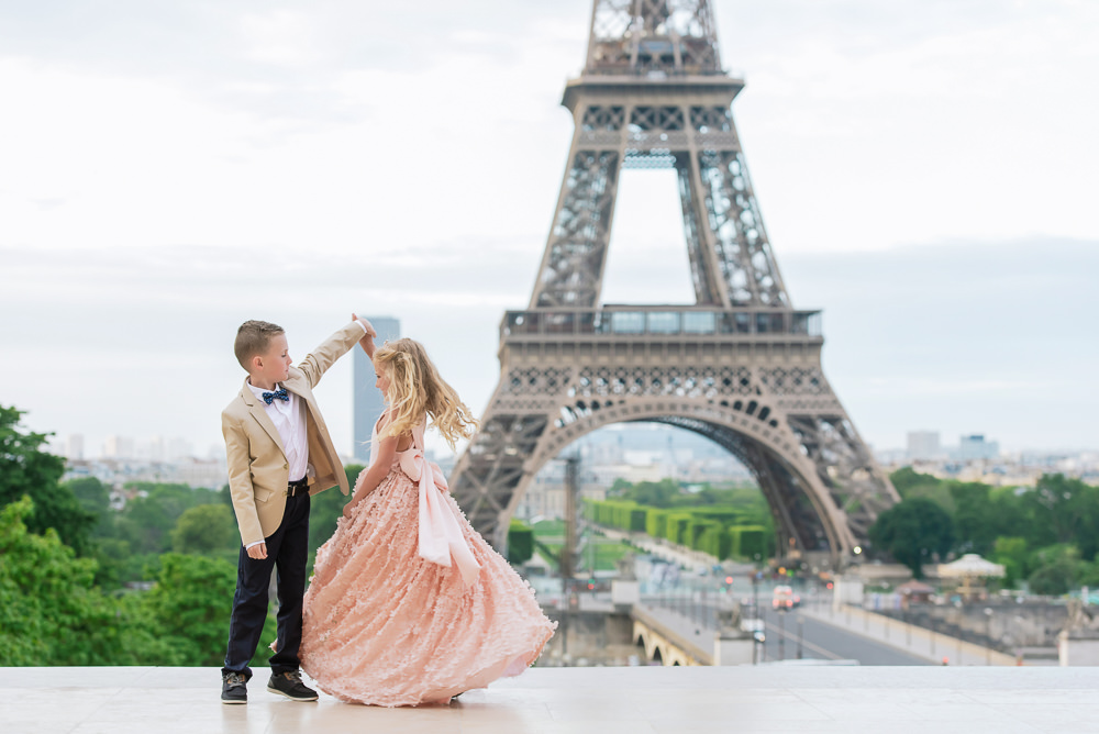 Brother and sister dancing in front of the Eiffel Tower at Trocadero