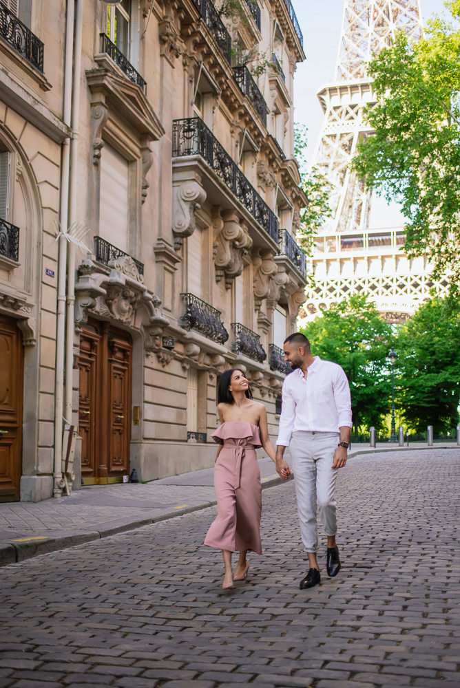 Couple walking hand in hand on a street with beautiful view of the Eiffel Tower