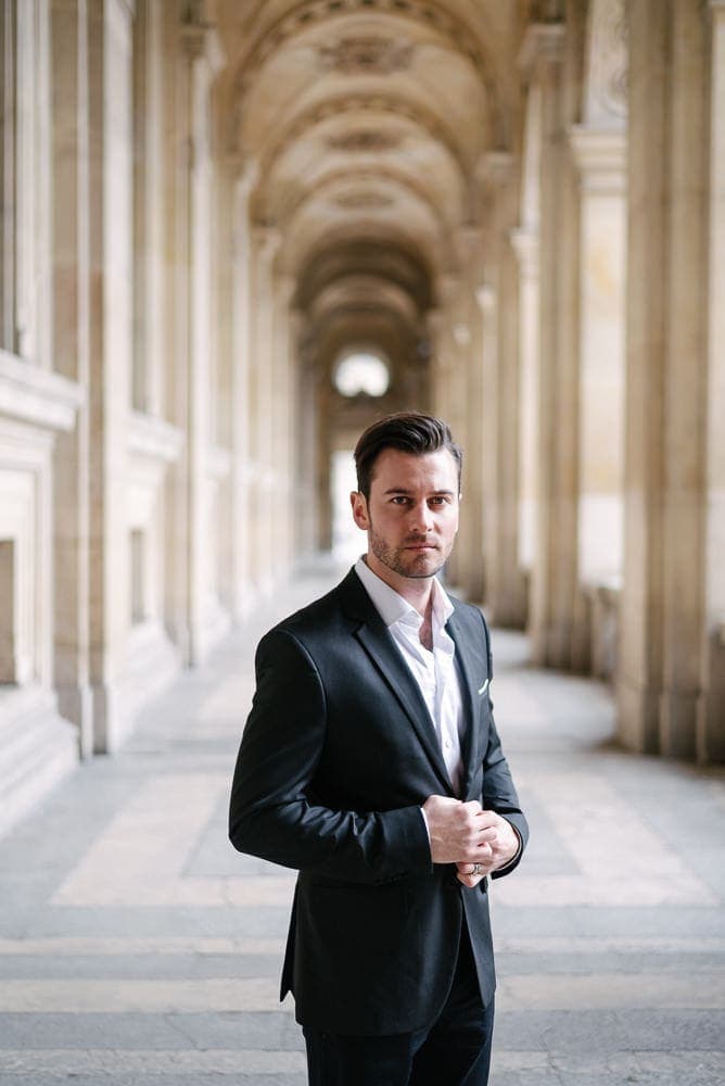couples portrait ideas - young man posing under the arches of the Louvre Museum