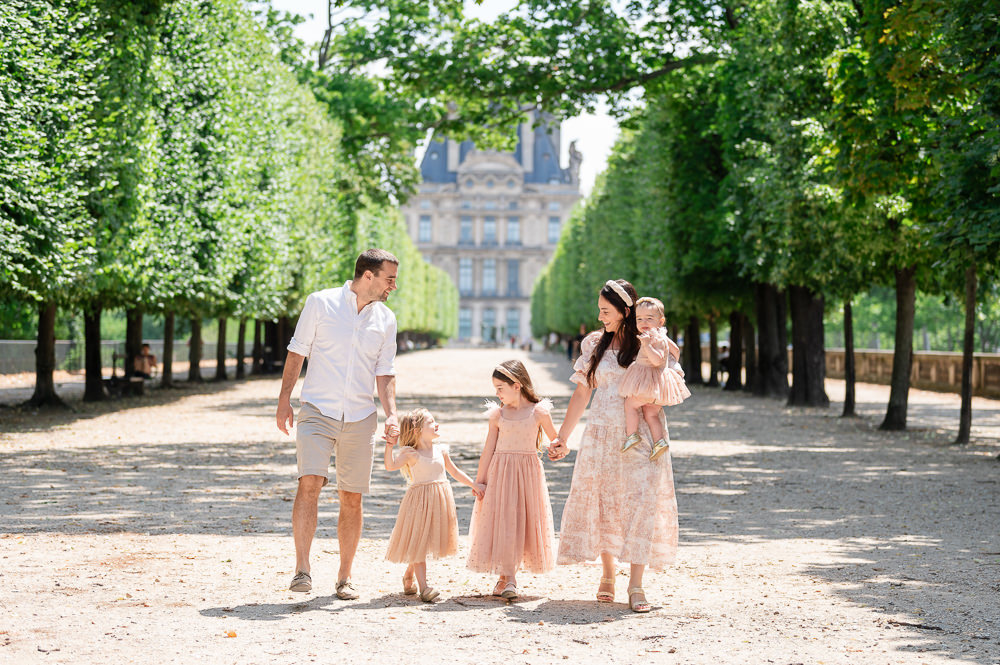 Cute family dressed for family photos having a stroll in the Tuileries Gardens in the summer