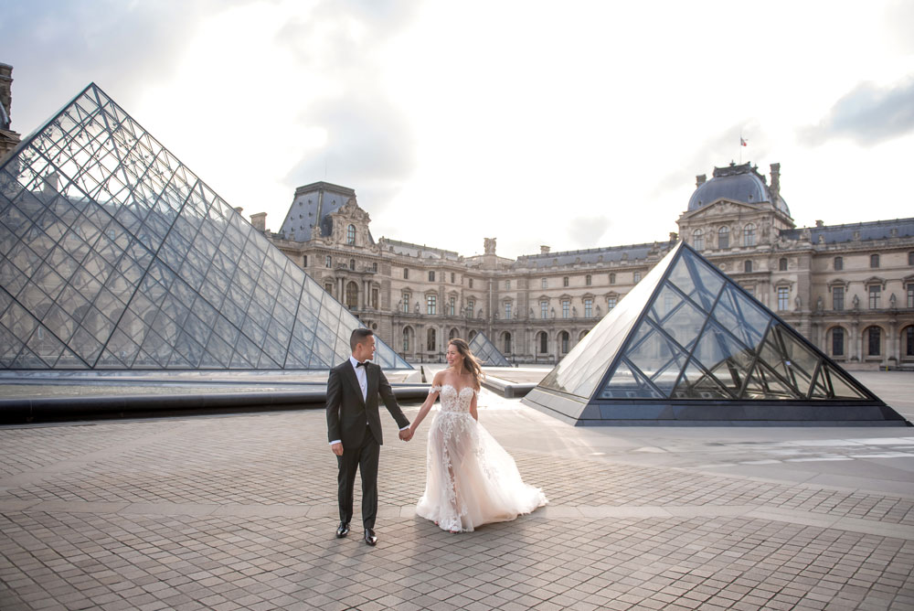 Couple posing at Louvre's glass pyramid