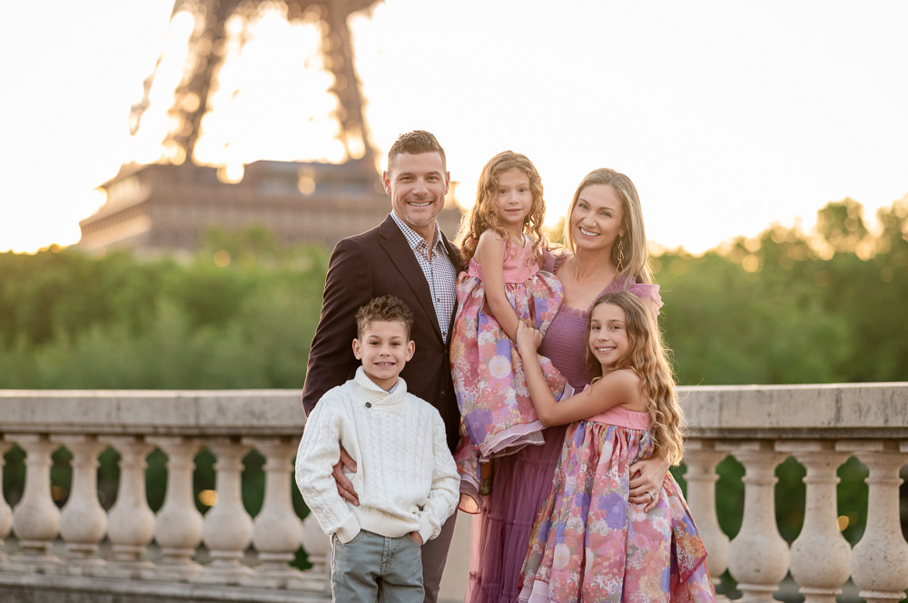 Family of 5 elegantly dressed posing for professional photos in front of the Eiffel Tower
