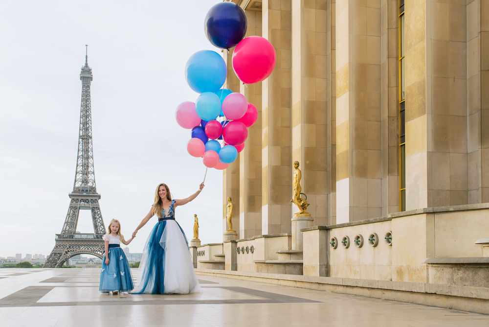 Family photos with many colorful balloons at the Eiffel Tower