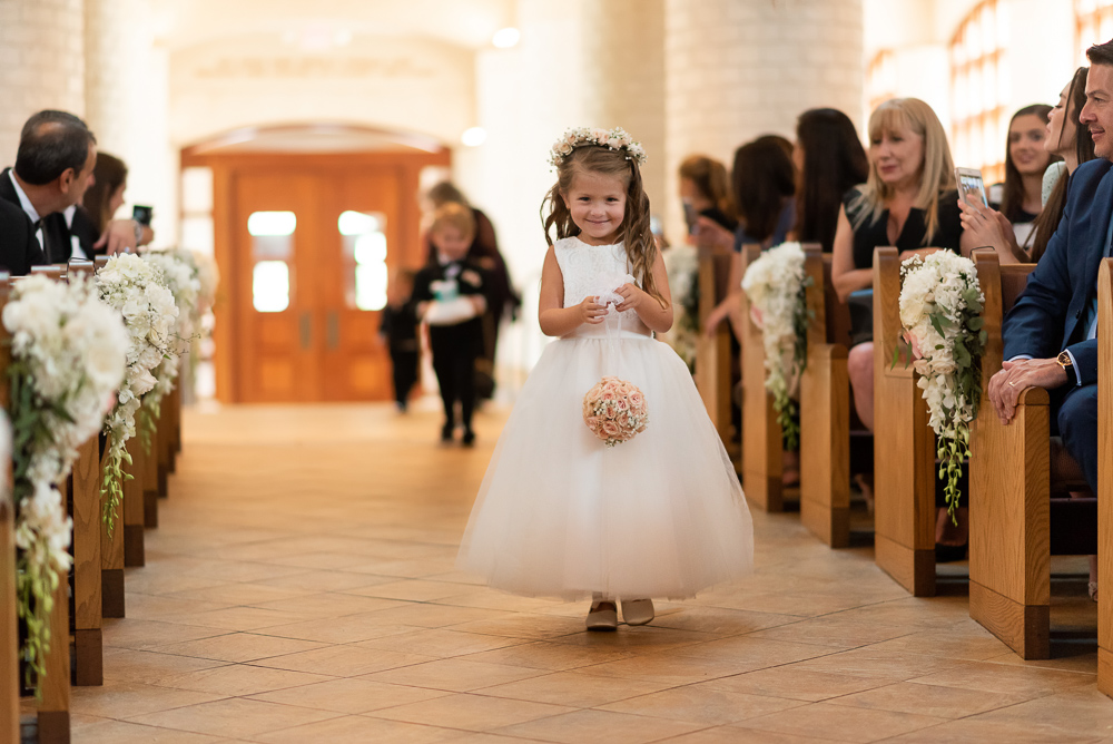 Flower girl bringing wedding bands during ceremony