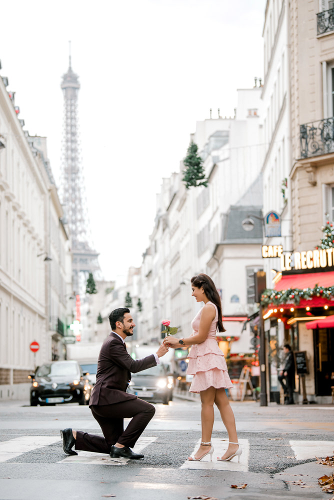 Gentleman on one knee offering rose to his fiancée
