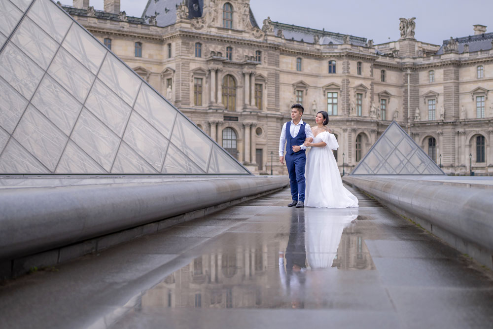 Couple strolling at the Louvre pyramid during a Paris photoshoot