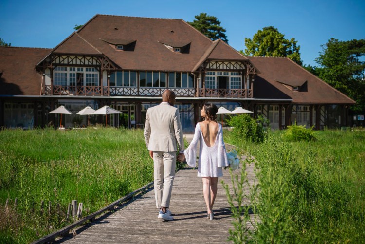 Newly married couple walk into their wedding venue in Paris Le Pavillon des etangs