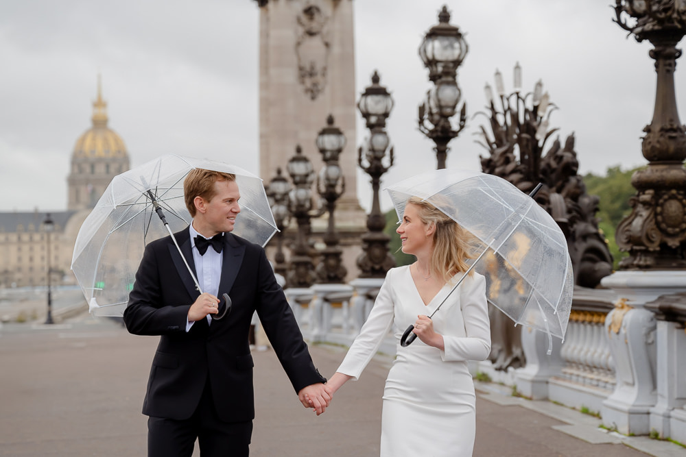 Paris elopement in the rain - bride and groom with umbrellas on the Alexander 3 bridge