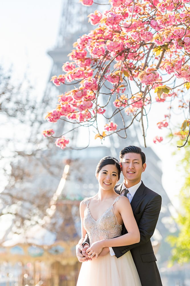 paris pre wedding photography bride and groom posing under the cherry blossoms by the eiffel tower