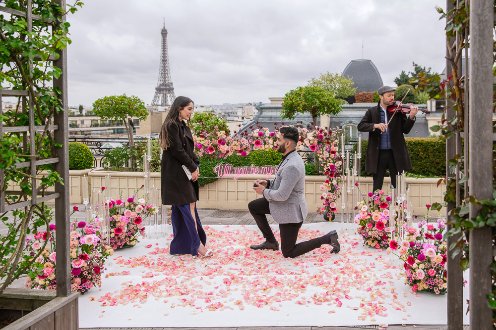 Red flowers romantic setup for surprise engagement on a rooftop in Paris