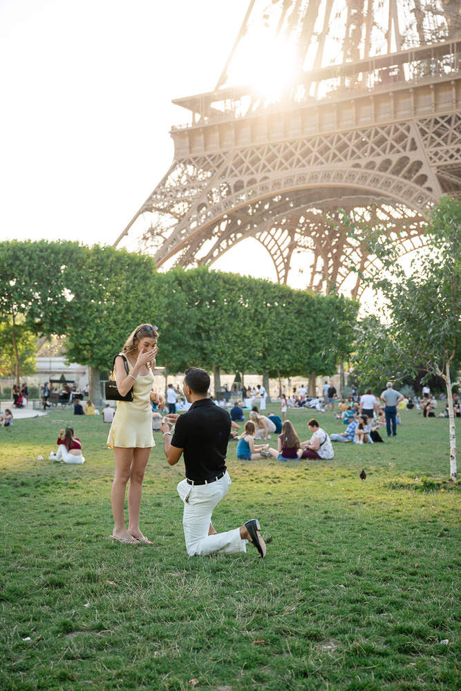 Surprise marriage proposal in Paris at the foot of the Eiffel Tower in the summer at sunset