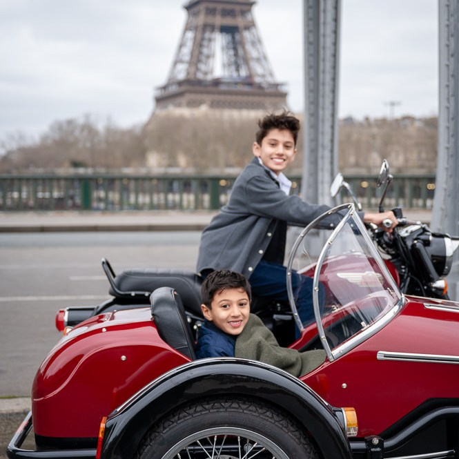 Two kids on a motorbike posing for professional family photos in Paris - Irene family photographer