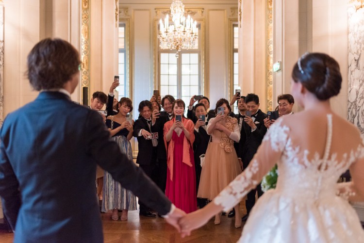 Wedding guests taking photos of the newly wed couple in Paris France