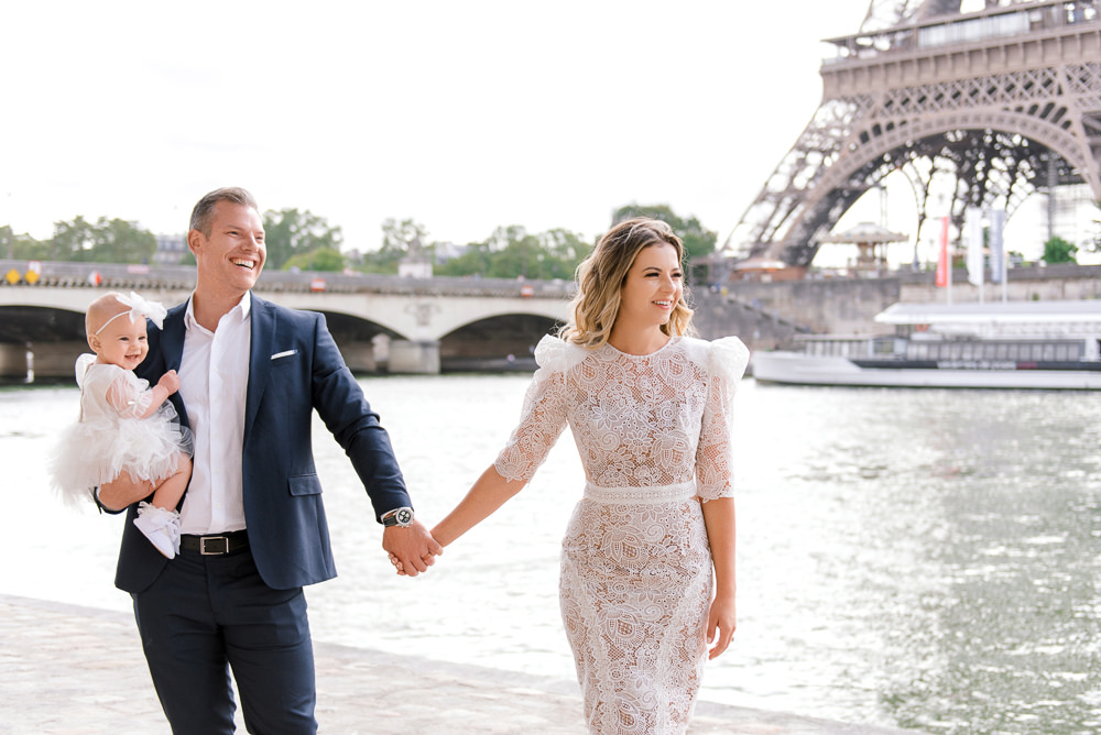 Young family posing for professional family photographer in Paris at Eiffel