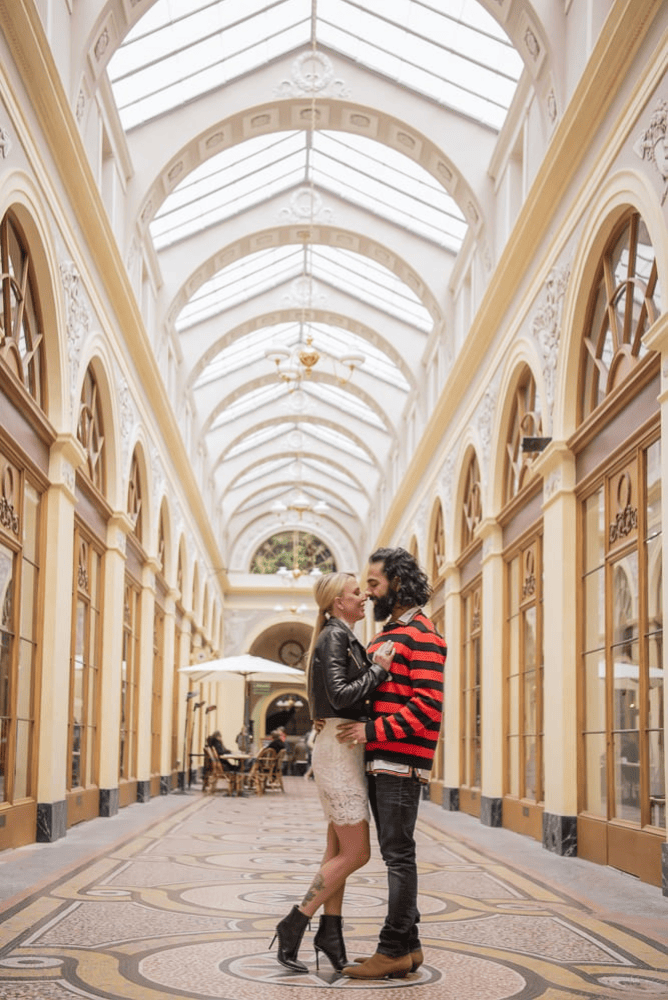 blonde woman and a man with long hair hugging in Gallerie Vivienne